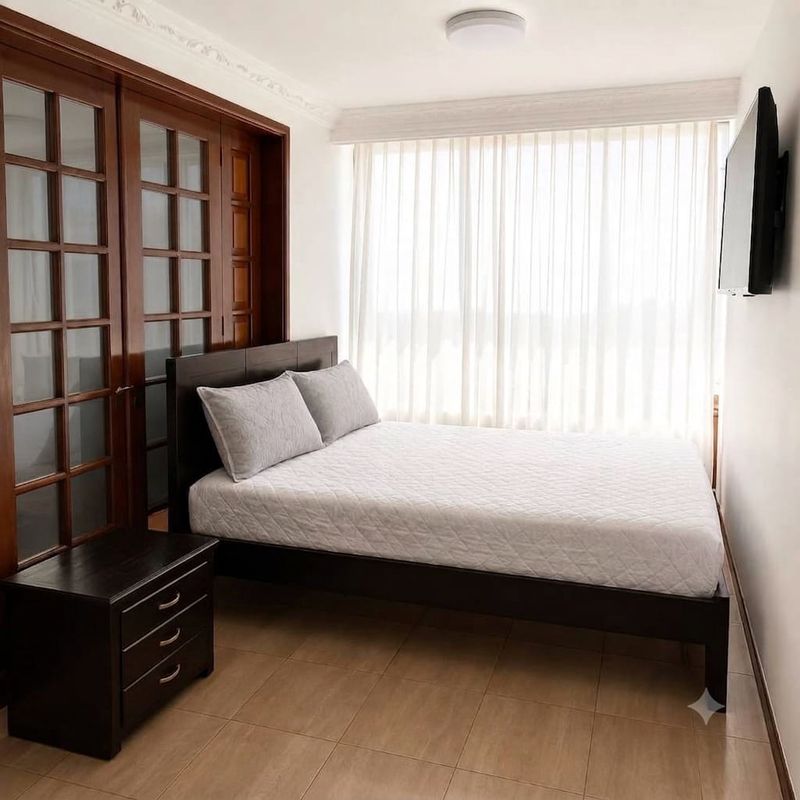 Comfort: cama con clóset de puertas talladas y televisor.